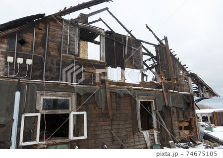 Burnt wooden house. House after the fire. Burned brick house with burnt roof inside view 74675105