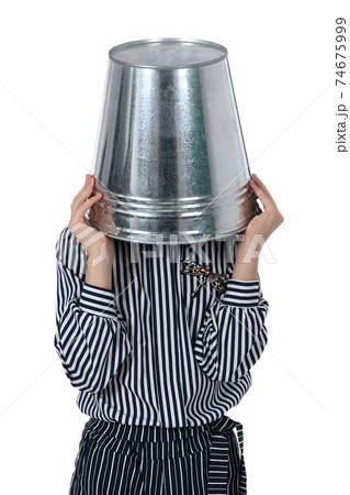 Young girl with metal bucket on head. Young girl with metal bucket on head. 74675999