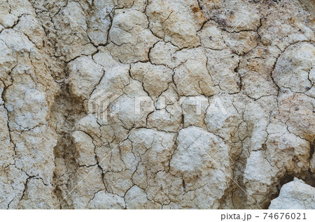 Dry white clay, natural material, atmospheric impact, outdoors. Background cracked, horizontal close-up photo. 74676021