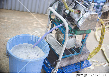 さとうきびを絞り圧搾機にかけ、煮詰めて黒糖を手作り 74676074