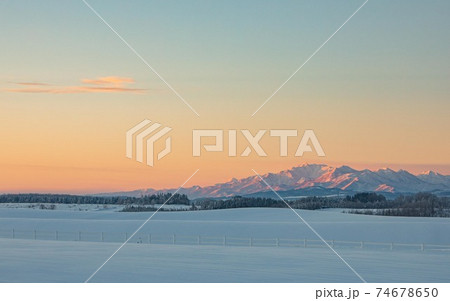 【北海道美瑛町】十勝岳連邦と朝焼けの丘　1月 74678650