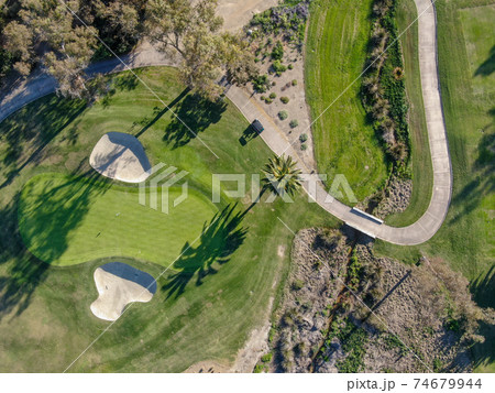 Aerial view over golf field. Aerial view over golf field. 74679944