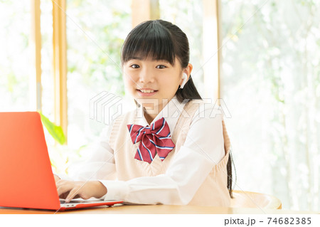 リビングでオンライン学習をする中学生の女の子 リビングでオンライン学習をする中学生の女の子 74682385