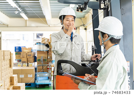 倉庫でフォークリフトを運転する女性作業員 74683433