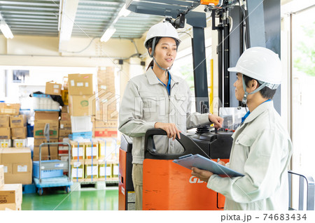 倉庫でフォークリフトを運転する女性作業員 74683434