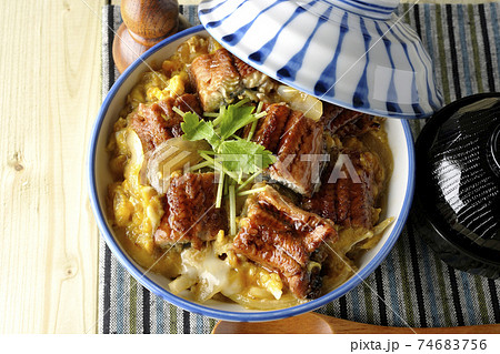 ランチョンマットの上の鰻蒲焼きを卵でとじたうな玉丼とお吸い物のセットと木製スプーンを俯瞰で撮影 ランチョンマットの上の鰻蒲焼きを卵でとじたうな玉丼とお吸い物のセットと木製スプーンを俯瞰で撮影 74683756