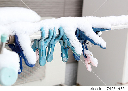 物干し竿の洗濯バサミに積もった雪 74684975