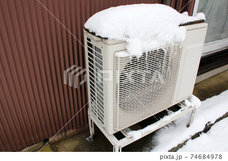 雪がかぶったエアコンの室外機 74684978