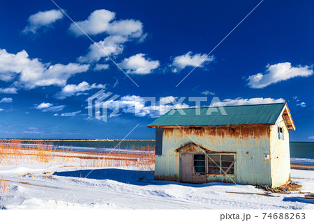 北海道 冬の海沿いの一軒家の風景の写真素材