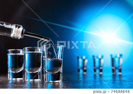 Vodka poured into a glass lit with blue backlight. 74688648
