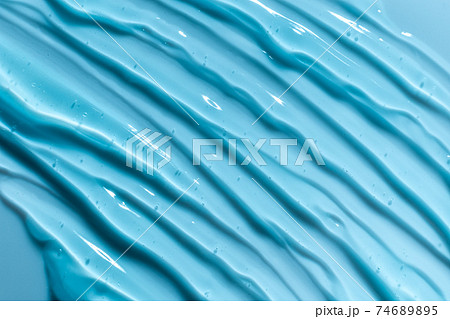 Blue gel texture. Hand sanitizer, alcohol gel background. Cosmetic clear liquid cream smudge. Transparent skin care product sample closeup Blue gel texture. Hand sanitizer, alcohol gel background. Cosmetic clear liquid cream smudge. Transparent skin care product sample closeup 74689895