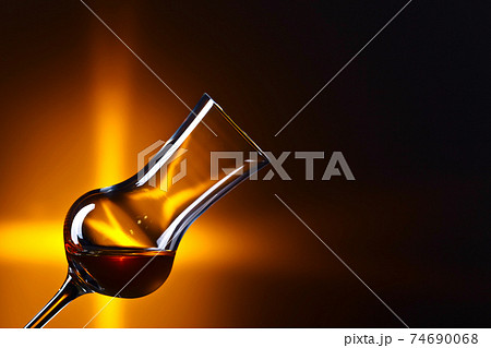 Glass of alcohol on a dark background 74690068