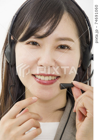 ヘッドセットを付けて仕事をする女性 ヘッドセットを付けて仕事をする女性 74691060