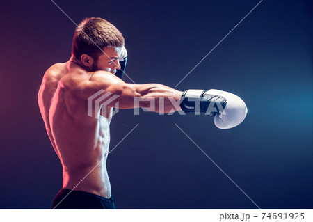 shirtless boxer with gloves on dark background shirtless boxer with gloves on dark background 74691925