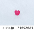 雪の上に落ちている山茶花のハートの花びら　冬イメージ 74692684