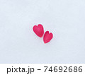 雪の上に落ちている山茶花のハートの花びら　冬イメージ 74692686