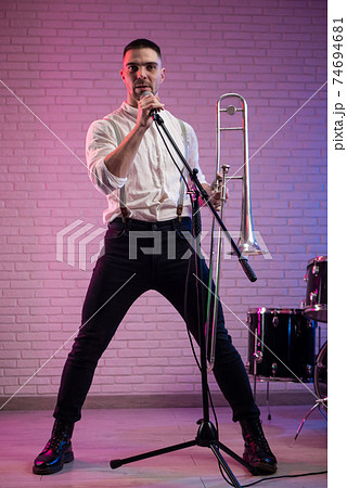 the man with a trombone in a club in neon light 74694681