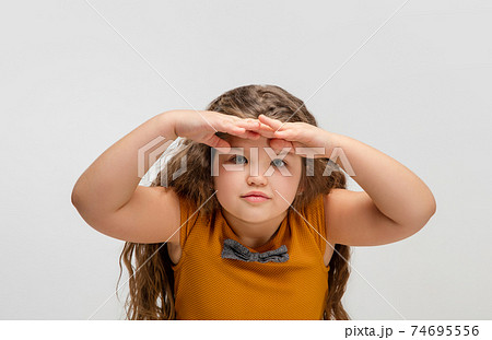 Happy caucasian little girl isolated on studio background. Looks happy, cheerful, sincere. Copyspace. Childhood, education, emotions concept 74695556