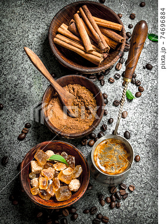 Coffee background. Coffee in turkey with crystals of sugar, cinnamon and ground coffee. Coffee background. Coffee in turkey with crystals of sugar, cinnamon and ground coffee. 74696884