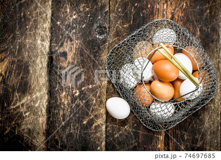 Fresh eggs in a mesh bag. 74697685
