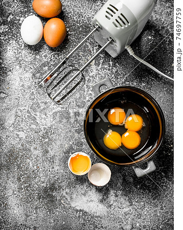 Baking background. Blend eggs with a mixer to make a dough. 74697759