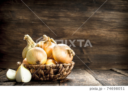 Fresh onions in a basket. 74698051