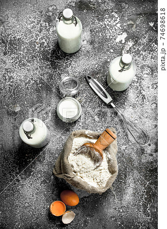 Baking background. Flour with fresh milk in bottles, sour cream and eggs. 74698618