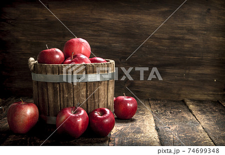 Red ripe apples in a wooden bucket. 74699348