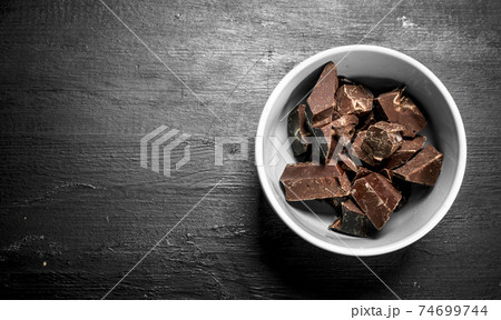 Chunks of chocolate in a bowl. 74699744