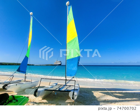 Colorful sailboats and motorboat, on a tropical beach at Half Moon Cay in the Bahamas 74700702