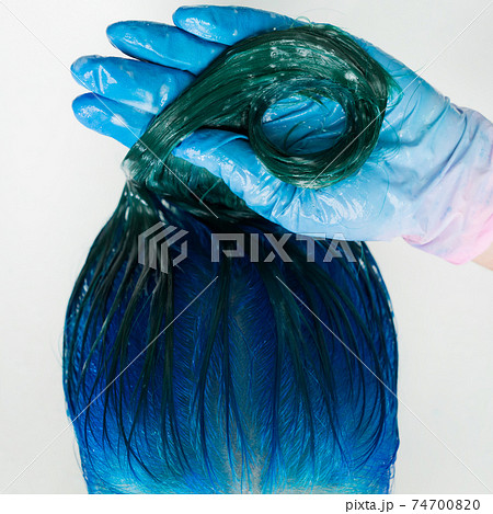 Washing of woman hair with shampoo in sink with special shower. Top view of hairstylist in gloves washes customer long hair sapphire color 74700820
