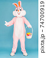 Easter bunny or rabbit or hare with basket of colored eggs, having fun, dancing, celebrates Happy easter. Easter rabbit isolated on blue background 74700919