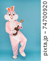 Crazy guitarist is playing music by ukulele or Hawaiian guitar. Easter bunny or rabbit or hare celebrates Happy easter, plays music by instrument. 74700920