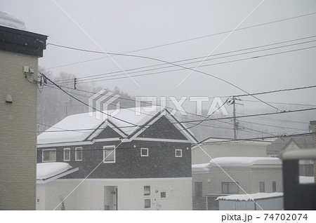 爆弾低気圧による暴風雪で切れそうな電線 74702074