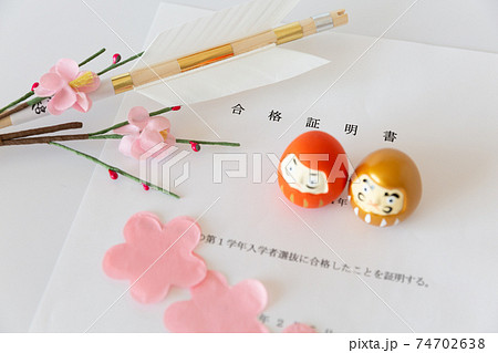 入試の合格証書とダルマ、合格祈願の破魔矢、桜の花びら 74702638