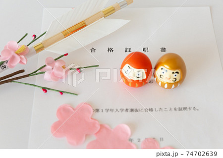 入試の合格証書とダルマ、合格祈願の破魔矢、桜の花びら 74702639