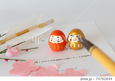 入試の合格証書とダルマ、合格祈願の破魔矢、桜の花びら 入試の合格証書とダルマ、合格祈願の破魔矢、桜の花びら 74702644