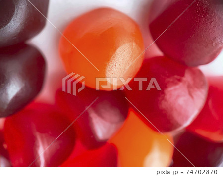 Close-up texture of red, orange and purple multivitamin gummies. Healthy lifestyle concept. Close-up texture of red, orange and purple multivitamin gummies. Healthy lifestyle concept. 74702870