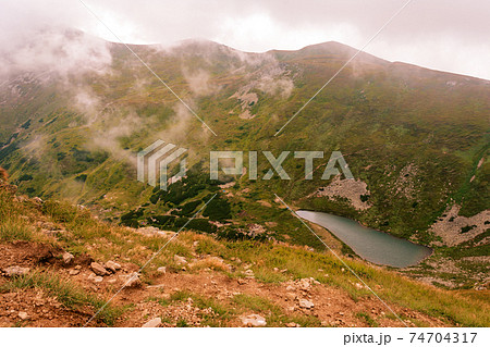 View from Mount Gutyn Tomnatyk to Lake Brebeneskul, a lake in the valley of the Carpathian Mountains, the highest lake in Ukraine. 74704317