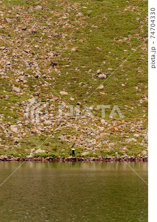 Beautiful and picturesque Carpathian lake Brebeneskul, a guy on the edge of the lake, the edge of the mighty mountains, a lake in the valley. 74704330