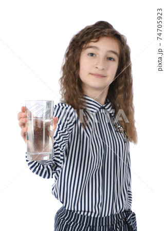 Beautiful young girl holding a glass of clean mineral water in her hand 74705923