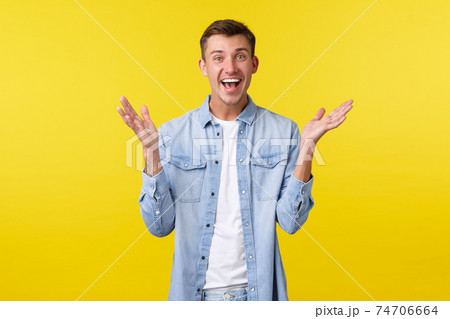 Happy excited handsome guy clap hands, react to fantastic news, congratulating friend with achievement, applause and smiling upbeat, standing enthusiastic over yellow background 74706664