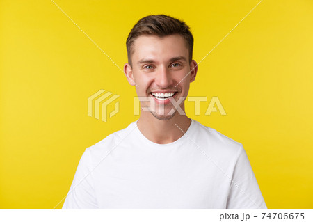 Lifestyle, summer and people emotions concept. Enthusiastic handsome male model with happy smile and white teeth, standing in casual t-shirt over yellow background satisfied Lifestyle, summer and people emotions concept. Enthusiastic handsome male model with happy smile and white teeth, standing in casual t-shirt over yellow background satisfied 74706675