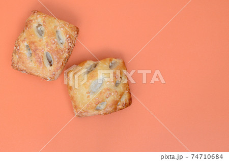 A satisfying meat patty, which combines an airy puff pastry and a delicate pork filling with onions. Baking on an orange background 74710684