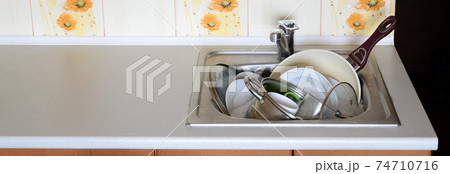 Dirty dishes and unwashed kitchen appliances filled the kitchen sink Dirty dishes and unwashed kitchen appliances filled the kitchen sink 74710716