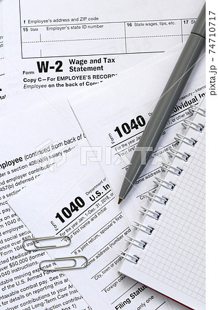 The pen and notebook is lies on the tax form 1040 U.S. Individual Income Tax Return. The time to pay taxes 74710717