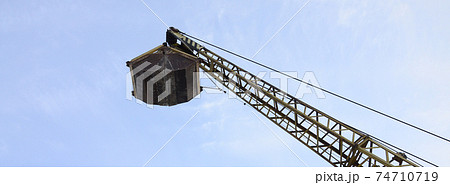 Old yellow mechanical clamshell grab on blue sky background 74710719