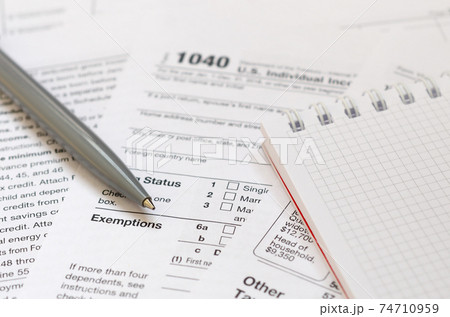 The pen and notebook is lies on the tax form 1040 U.S. Individual Income Tax Return. The time to pay taxes The pen and notebook is lies on the tax form 1040 U.S. Individual Income Tax Return. The time to pay taxes 74710959