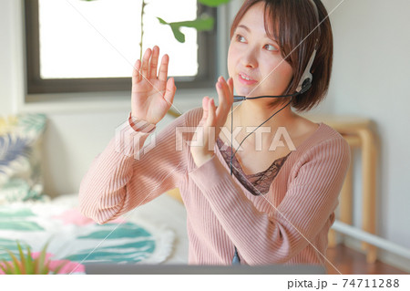 オンラインミーティング_棚の上に載せて_と身振りを交え話す女性 74711288