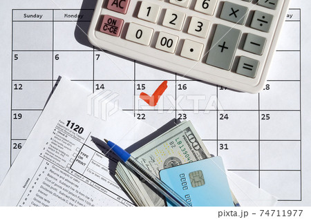 1120 Corporation Income Tax Return blank with dollar bills, calculator and pen on calendar page with marked 15th April 1120 Corporation Income Tax Return blank with dollar bills, calculator and pen on calendar page with marked 15th April 74711977